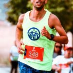 Focused athlete running a vibrant outdoor marathon in bright attire.